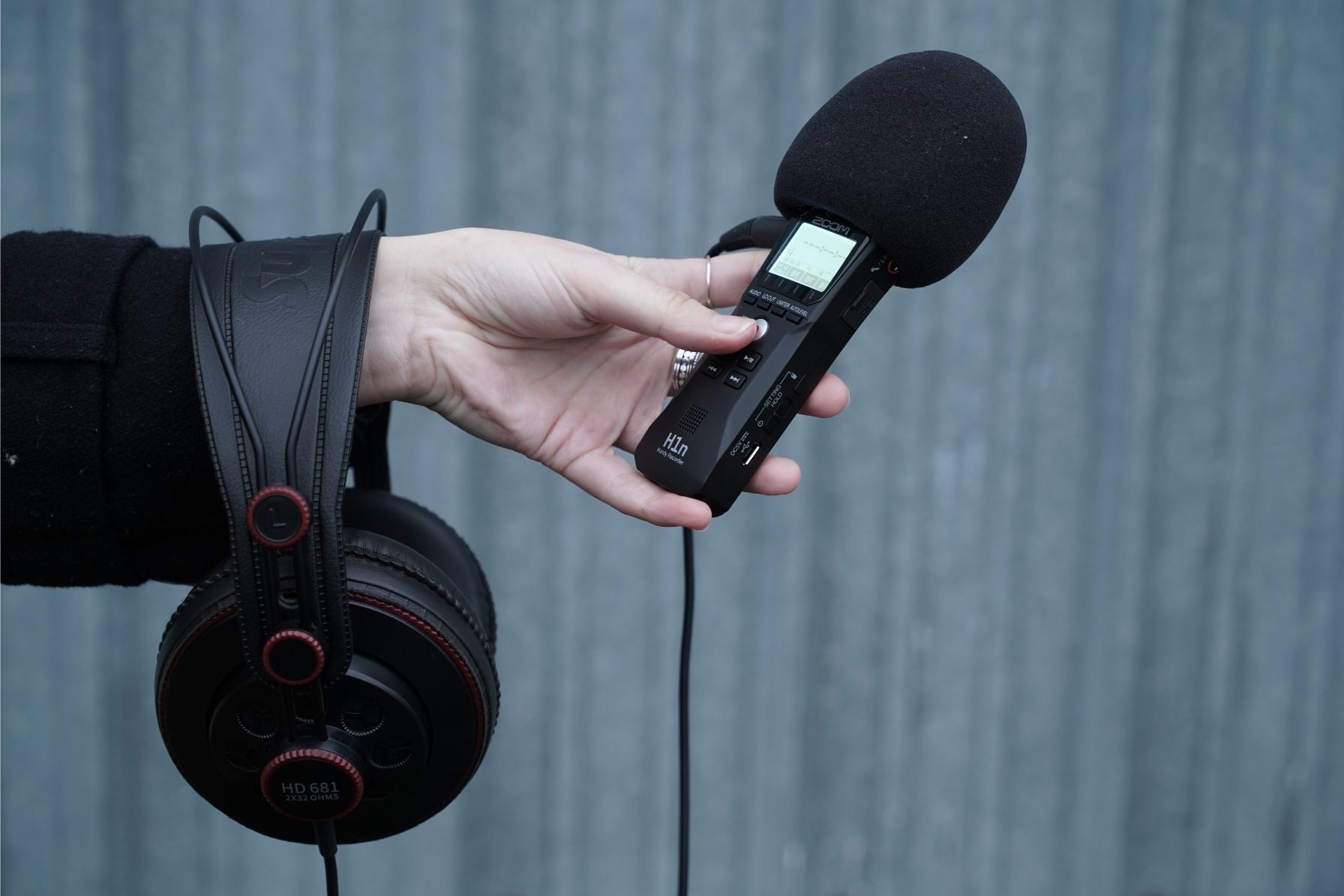 Une main qui tient un enregistreur et un casque audio